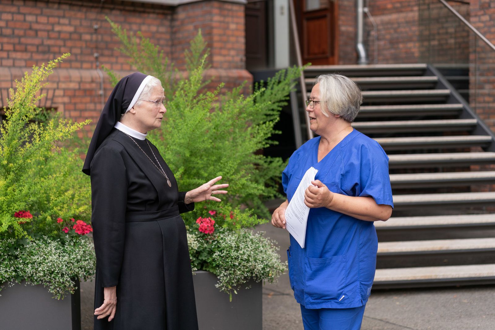 Ordensschwester im Gespräch mit Krankenschwester