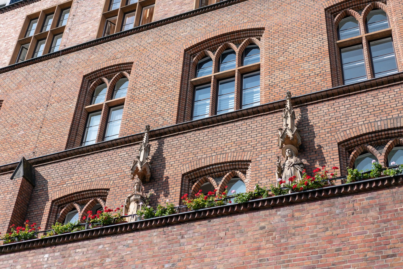 Hauptgebäude mit Steinfiguren der heiligen Hedwig und dem heiligen Karl Borromäus